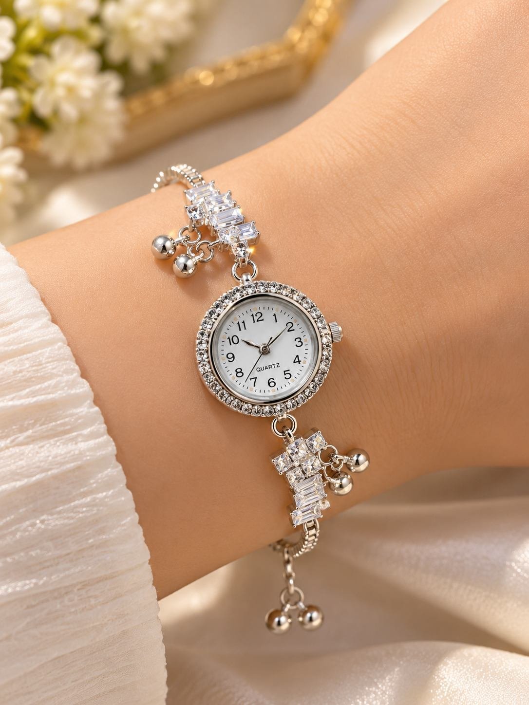 Silver-tone bracelet watch with white dial and stone-set bezel beside a double band ring with a round clear stone, combo for women — image 4