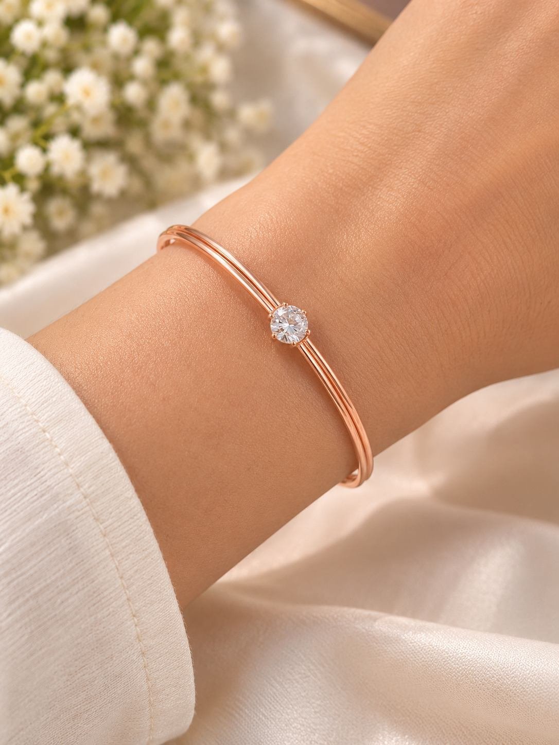 Rose gold-tone double line bangle-style bracelet for women with one round clear crystal in a prong setting, worn on the wrist — image 2